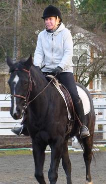 Carol wears helmet and rides a horse